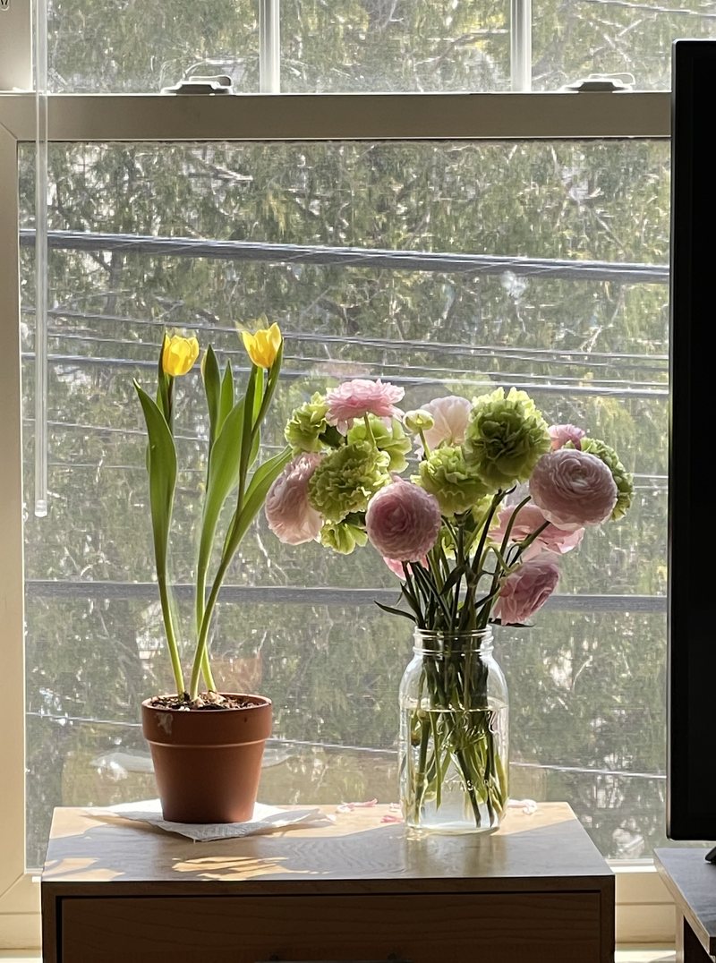 A flower arrangement in a vase on a windowsill