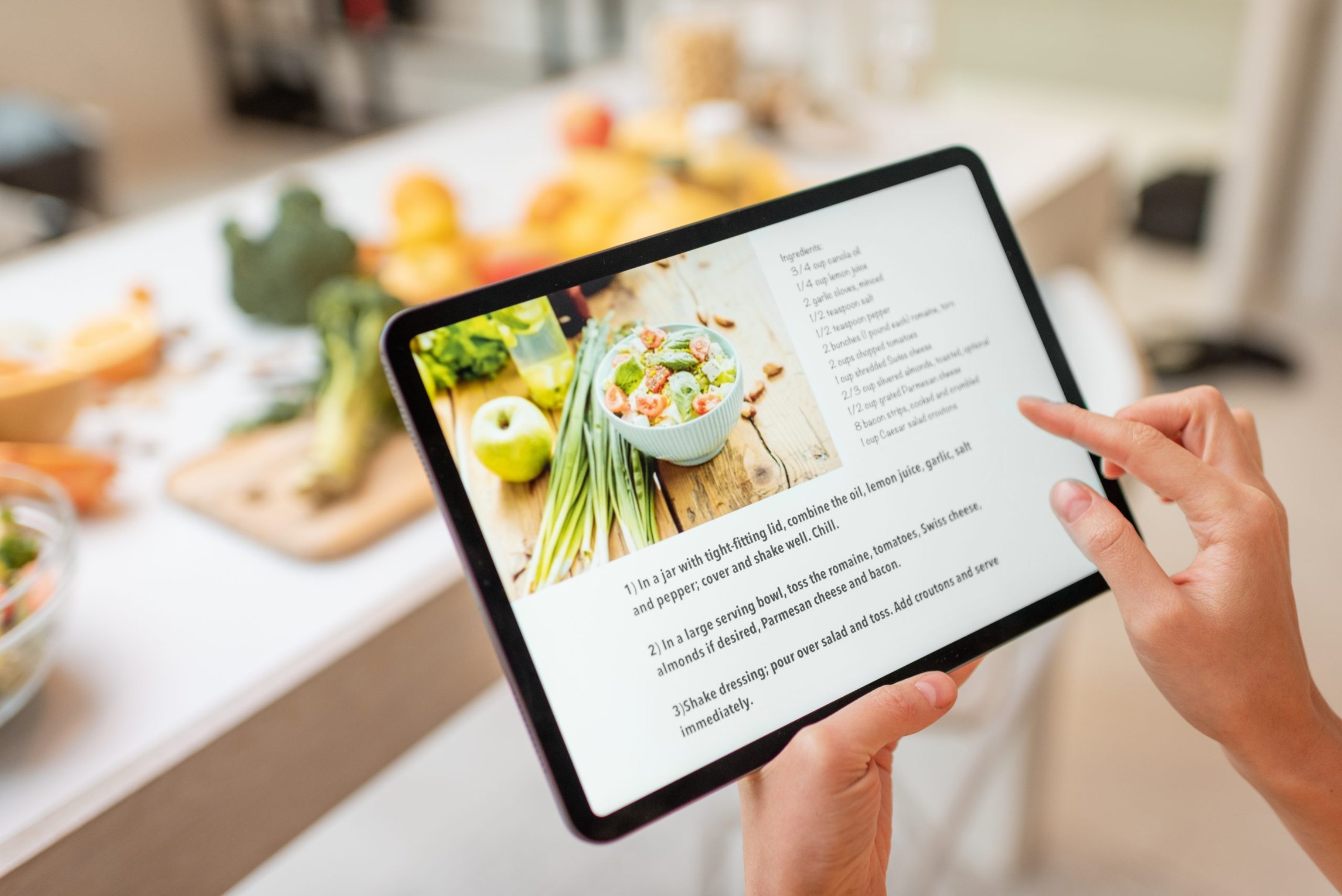 A cook following a written digital recipe on a tablet while preparing food